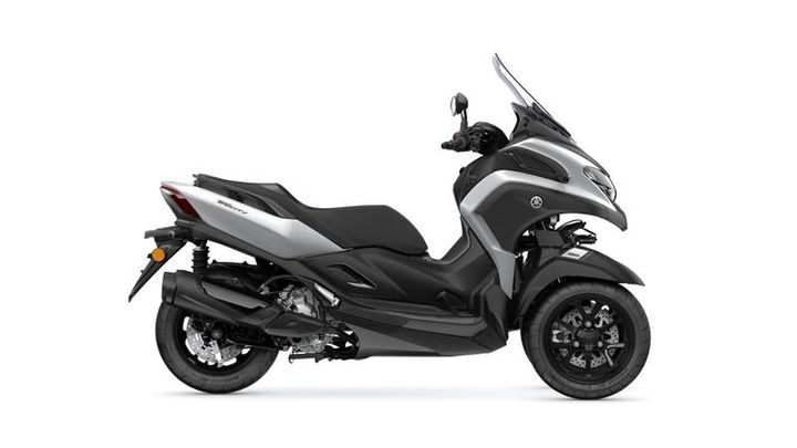 A sleek, modern three-wheeled scooter in silver and black, featuring a front fairing, large windshield, and sporty design elements.