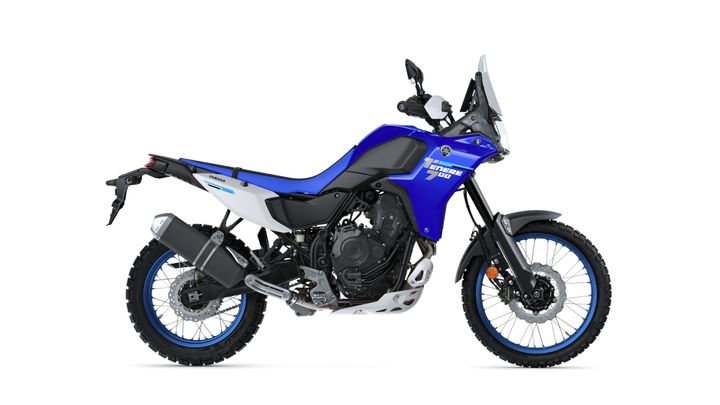 A blue and white Yamaha Tenere 700 motorcycle is shown in profile, featuring a black seat, rugged tires, and an off-road design, set against a plain white background.