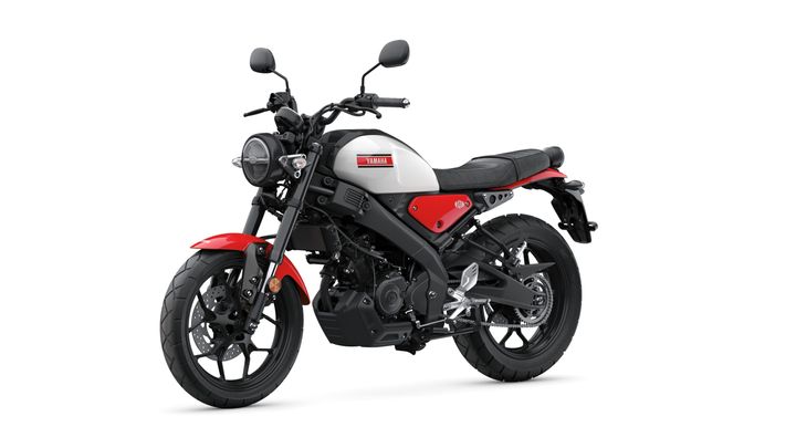 A sleek Yamaha motorcycle with a white and red color scheme, featuring a black seat, prominent headlamp, and modern design elements.