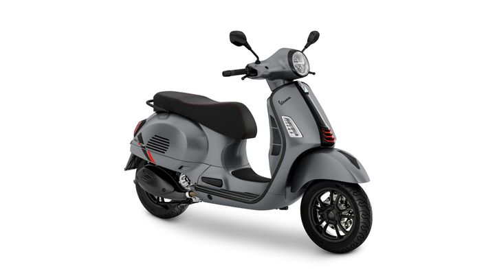 A sleek gray scooter with a black seat and red stitching, featuring a modern design, round headlight, and sporty accents.