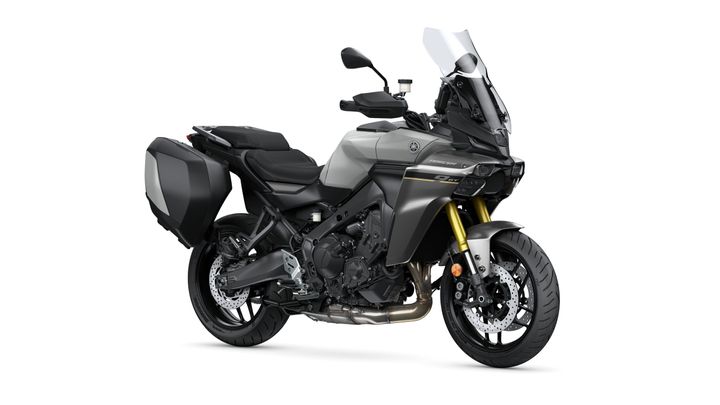 A sleek Yamaha motorcycle with a gray and black design, featuring saddlebags, a tall windshield, and gold front forks, positioned on a white background.
