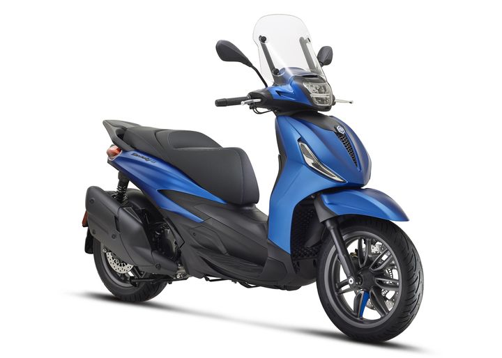 A sleek blue scooter with a windshield, showcasing a modern design and comfortable seating, positioned at a slight angle to highlight its features.