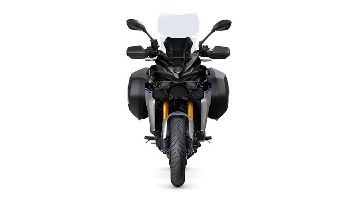 Front view of a modern motorcycle with a sleek design, featuring a prominent windshield, dual headlights, and wide side panniers.