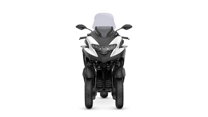 A front view of a modern three-wheeled motorcycle with a sleek design, featuring a prominent windshield and distinct lighting elements.