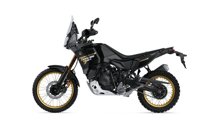 A black Yamaha Tenere 700 motorcycle with gold-accented wheels and rugged tires, shown from the side on a white background.