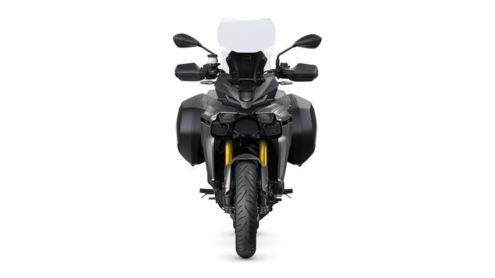 A stylish motorcycle viewed from the front, featuring a sleek design with a prominent windshield, dual headlights, and side panniers. The bike's gold front forks and detailed tire tread add to its modern aesthetic against a white background.