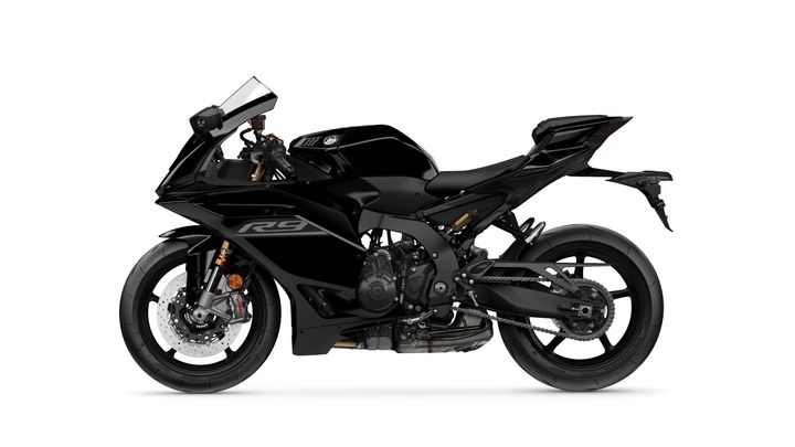 A sleek black sports motorcycle in profile view, featuring a fairing, a low seat, and aggressive body lines, with visible brakes and a chain drive.