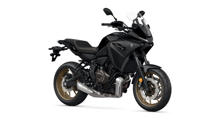 Yamaha 2023 Tracer 7 A sleek, black motorcycle with gold accents, featuring a sporty design, upright handlebars, and a prominent exhaust system, positioned on a white background.