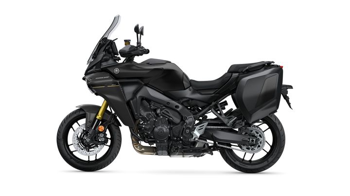 A sleek black motorcycle with a modern design, featuring a tall windshield, gold front forks, and side luggage compartments, positioned against a white background.