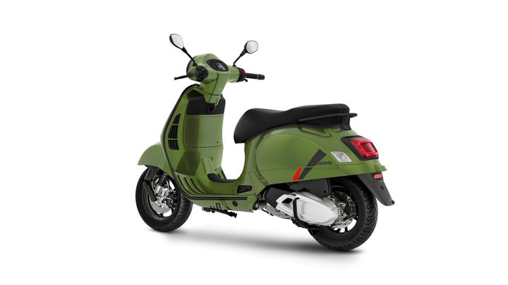 A green scooter positioned at an angle, showcasing its sleek design, black seat, and chrome accents.