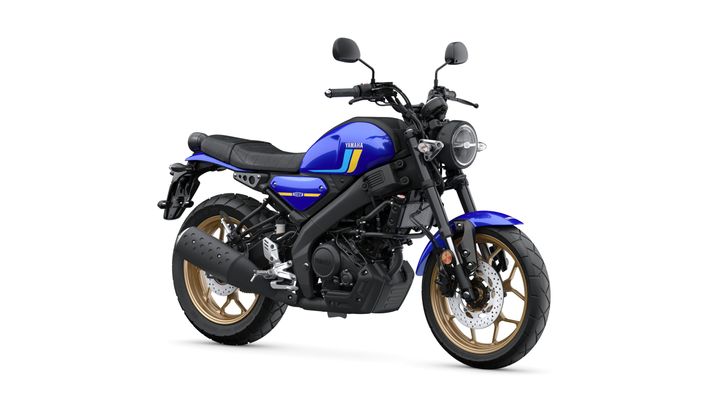 A blue Yamaha motorcycle with gold alloy wheels, a sleek black seat, and a round headlight, positioned at an angle against a white background.