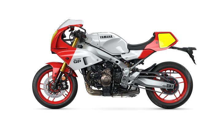 A sleek, modern Yamaha XSR900 GP motorcycle features a silver and red color scheme, with sporty design elements, including a prominent front fairing and distinctive wheel rims.