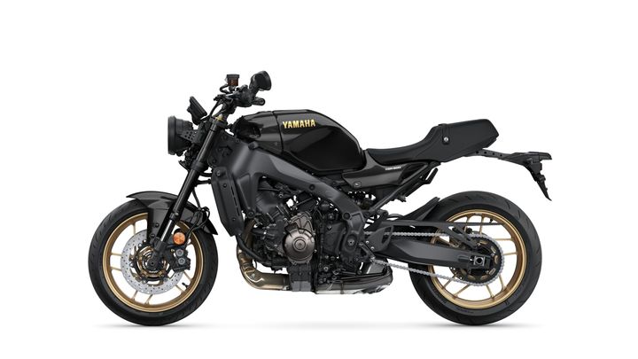 A sleek, black Yamaha XSR900 motorcycle with gold accents, displayed at a side angle against a white background.