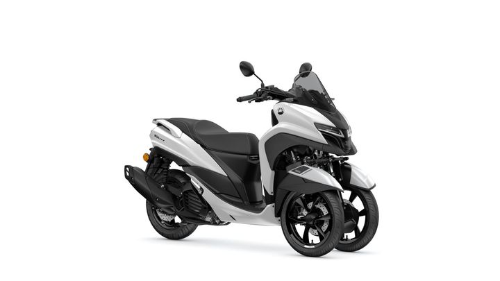 A sleek, modern three-wheeled scooter in white and black. The scooter features a streamlined body, a transparent windscreen, dual front wheels, and a single rear wheel, designed for urban mobility.