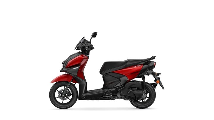 A sleek red Yamaha scooter is viewed from the side, showcasing its modern design, black seat, and sporty features.