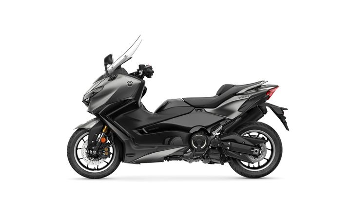 A sleek black Yamaha TMAX scooter positioned sideways, showcasing its aerodynamic design, large front shield, and modern features.