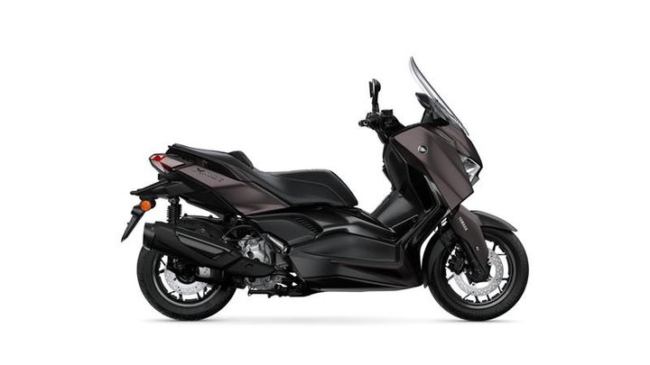 A sleek, modern black scooter with a prominent windshield, side mirrors, and a sporty design is shown from the side, highlighting its streamlined body and large wheels.