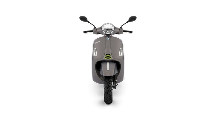 Front view of a modern grey scooter with a round headlight, two mirrors, and distinct design features including stylized lights and a textured tire.