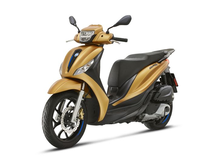 A golden scooter with a sleek design, featuring a comfortable seat, front headlight, and modern wheels, displayed at an angle to highlight its profile.