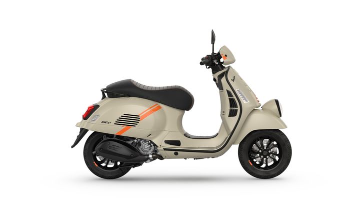 Vespa GTV 310 Euro 5+ A beige scooter with orange stripes, featuring a black seat and sleek design, viewed from the side against a white background.