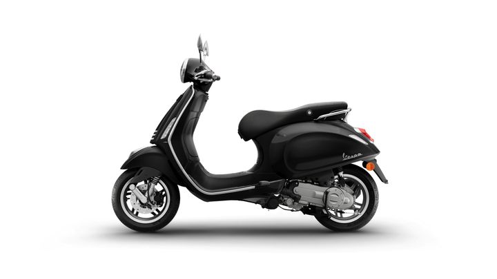 A sleek black Vespa scooter is shown from the side, featuring a rounded body, single seat, and stylish chrome accents. The rear light and mirrors are visible, along with detailed wheels.
