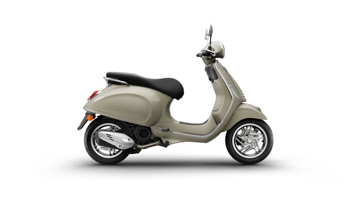 Vespa Primavera 125 Euro 5 + 2026 A stylish beige scooter with a sleek design and chrome accents, positioned against a white background.