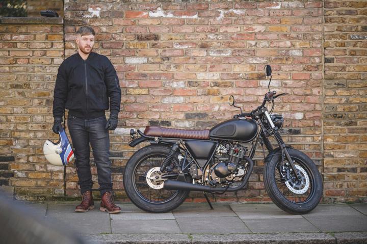 Mutt Motorbike against a brick wall with Helstons clothing