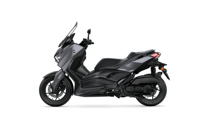 A sleek, matte black scooter with a modern design, featuring a high windshield, ergonomic seat, and a sporty stance, positioned on a white background.