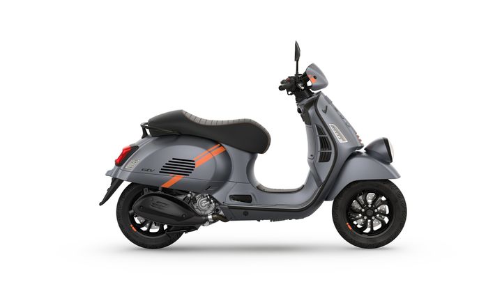 A modern gray scooter with orange accents, side view, featuring a stylish design and black wheels.