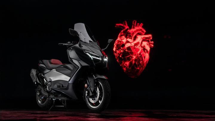 A sleek black motorcycle with a red and gray seat, positioned against a dark background, alongside a glowing, 3D-rendered red heart.
