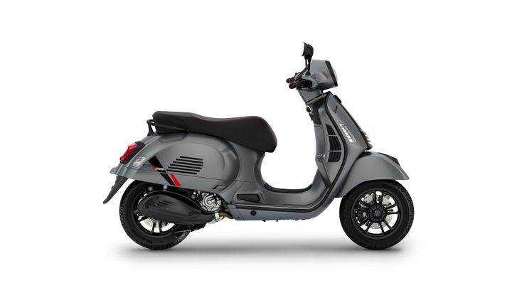 A sleek gray Vespa scooter is shown in profile against a white background, featuring sporty red accents and a modern design.
