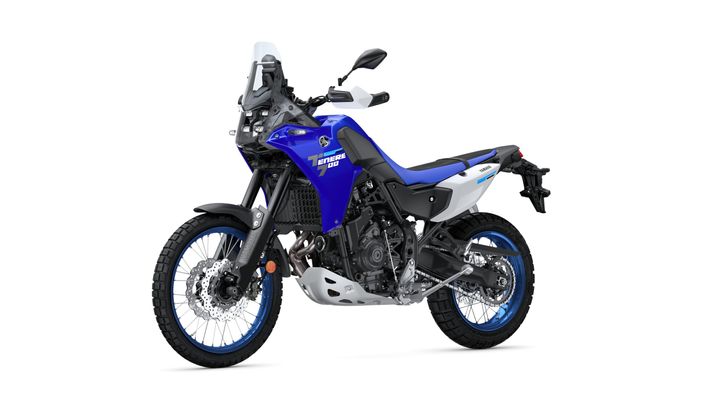 A side view of a blue and white Yamaha Tenere 700 motorcycle, featuring off-road tires, a sturdy frame, and a windscreen.