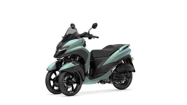 A teal three-wheeled scooter with a sleek design, featuring a windshield, dual front wheels, and a comfortable black seat, set against a white background.