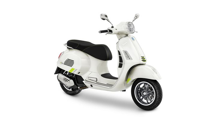 A sleek, white scooter with a black seat and green accents, positioned at a slight angle to showcase its design and features.