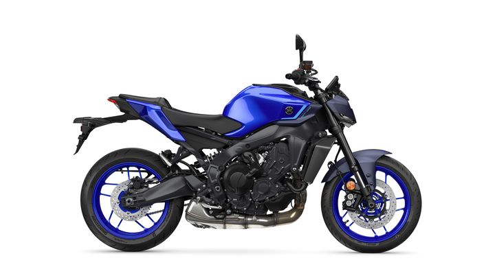 A side view of a blue Yamaha motorcycle showcasing its sleek design, featuring a modern frame, a comfortable seat, and distinctive blue wheels. The bike is set against a white background.
