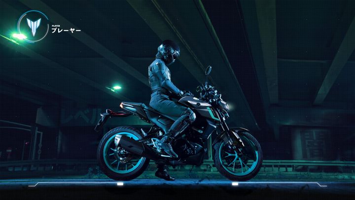 A futuristic motorcyclist in a sleek black suit and helmet sits on a modern motorcycle, illuminated by neon green lights in an urban environment. The background features an industrial setting with overhanging structures.