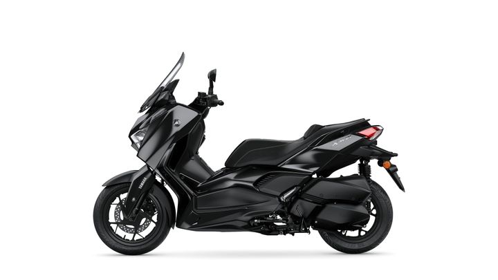 A sleek black scooter with a streamlined design, featuring a high windshield, sporty seat, and modern LED lights, viewed from the side.