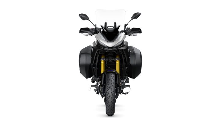 Front view of a modern motorcycle featuring a sleek design, prominent windshield, and side panniers. The bike has gold front forks and a detailed tire tread pattern.