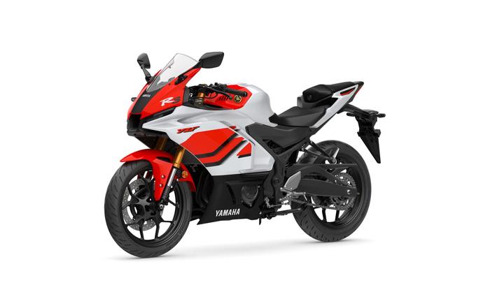 A Yamaha YZF-R3 motorcycle in white and red with sleek bodywork, a racing windscreen, and a sporty design, displaying its side profile against a white background.