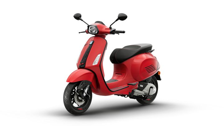 A vibrant red scooter with a sleek design, featuring a low seat, black accents, and stylish curves, positioned at an angle against a white background.