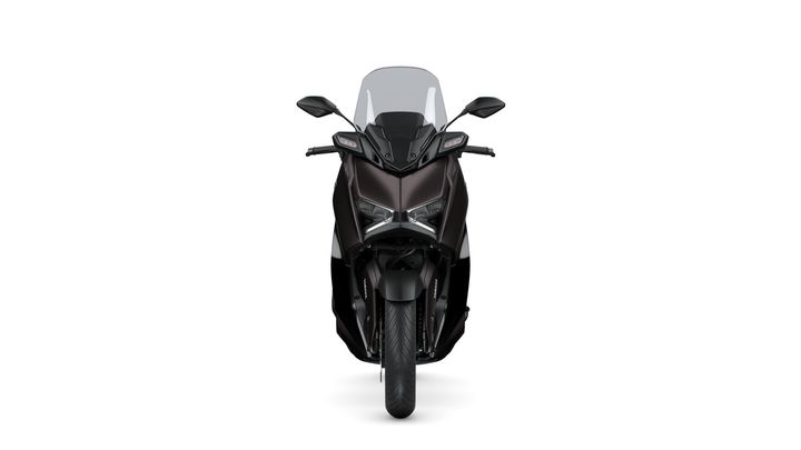 Front view of a sleek, modern motorcycle with a dark color scheme and prominent windscreen, showcasing its sharp headlights and distinctive design.