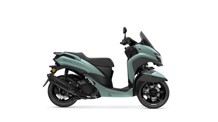 A teal and black scooter displayed from the side, showcasing its sleek design and modern features.