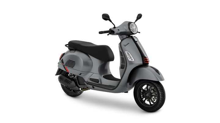A stylish gray scooter with a sleek design, featuring a comfortable black seat with red stitching, positioned angled to the right.