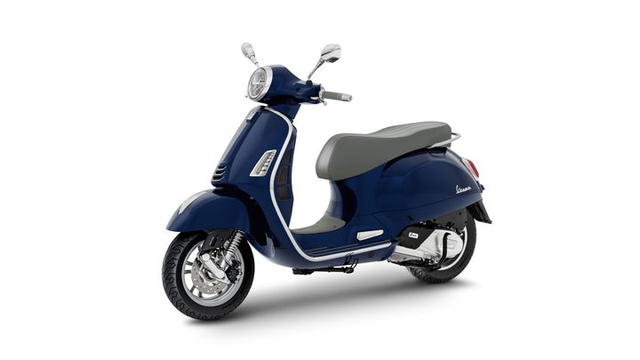 A dark blue scooter with a grey seat, featuring a chrome finish on the front and back, stands on a white background.