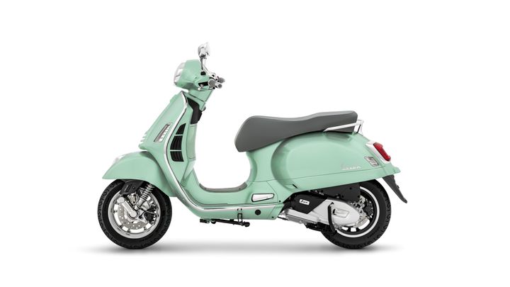 A mint green Vespa scooter shown from the side, featuring a modern design with silver accents and a gray seat against a white background.