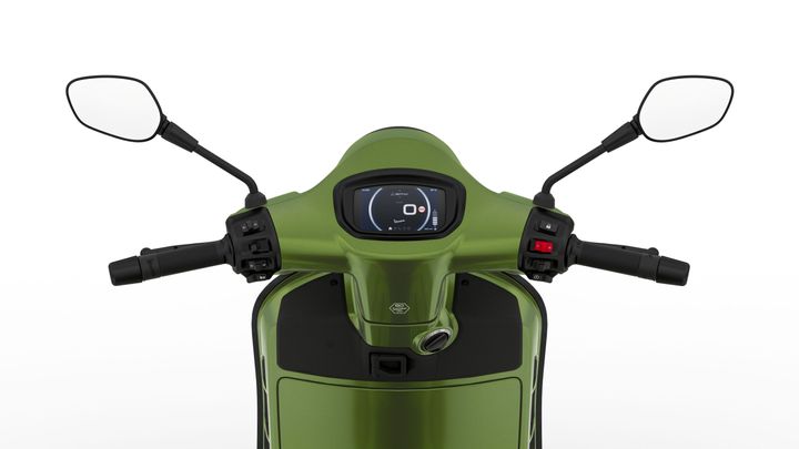 A top-down view of a green scooter's handlebars, featuring a digital display, mirrors, and control buttons.