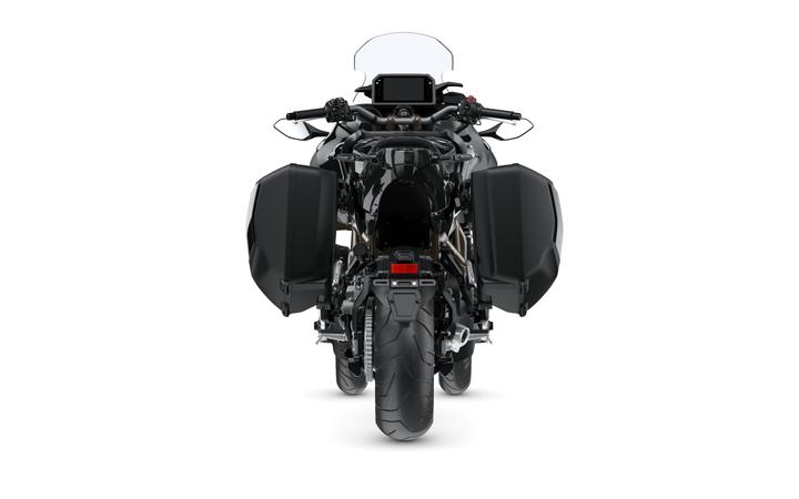 Rear view of a black motorcycle with side panniers, featuring a sleek design and visible exhaust, set against a white background.