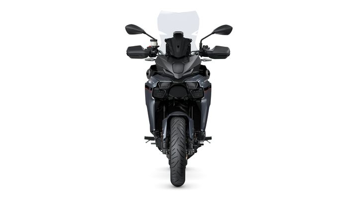 A front view of a modern motorcycle featuring a sleek design, dual headlights, a tall windscreen, and wide handlebars, set against a white background.