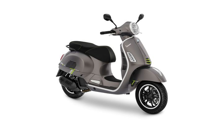 A sleek gray scooter with black accents and green detailing, featuring a comfortable seat, modern design elements, and visible front and rear wheels.