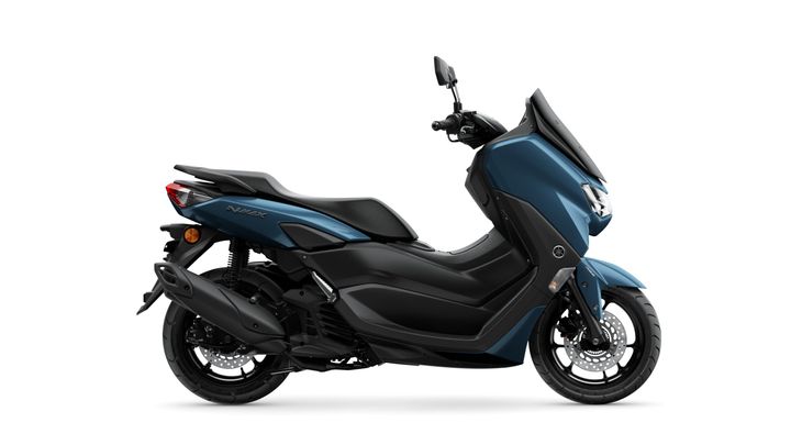 A blue Yamaha NMAX scooter is shown from the side, featuring a sleek design with a low seat, modern bodywork, and a prominent front light. The background is plain white.